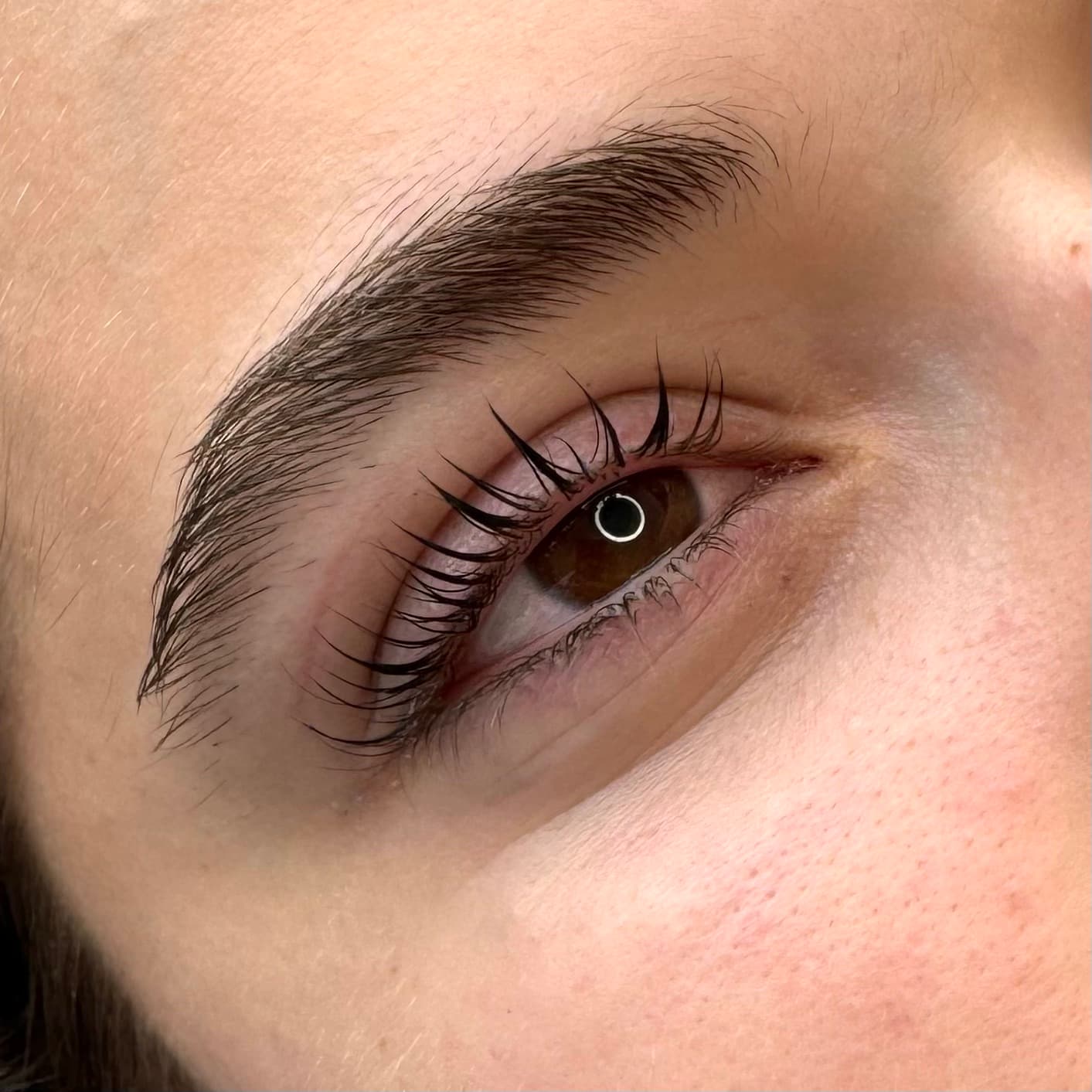 Courbure accentuée sur cliente aux yeux noisette, peau claire et sourcils définis, lash lift à Dijon.