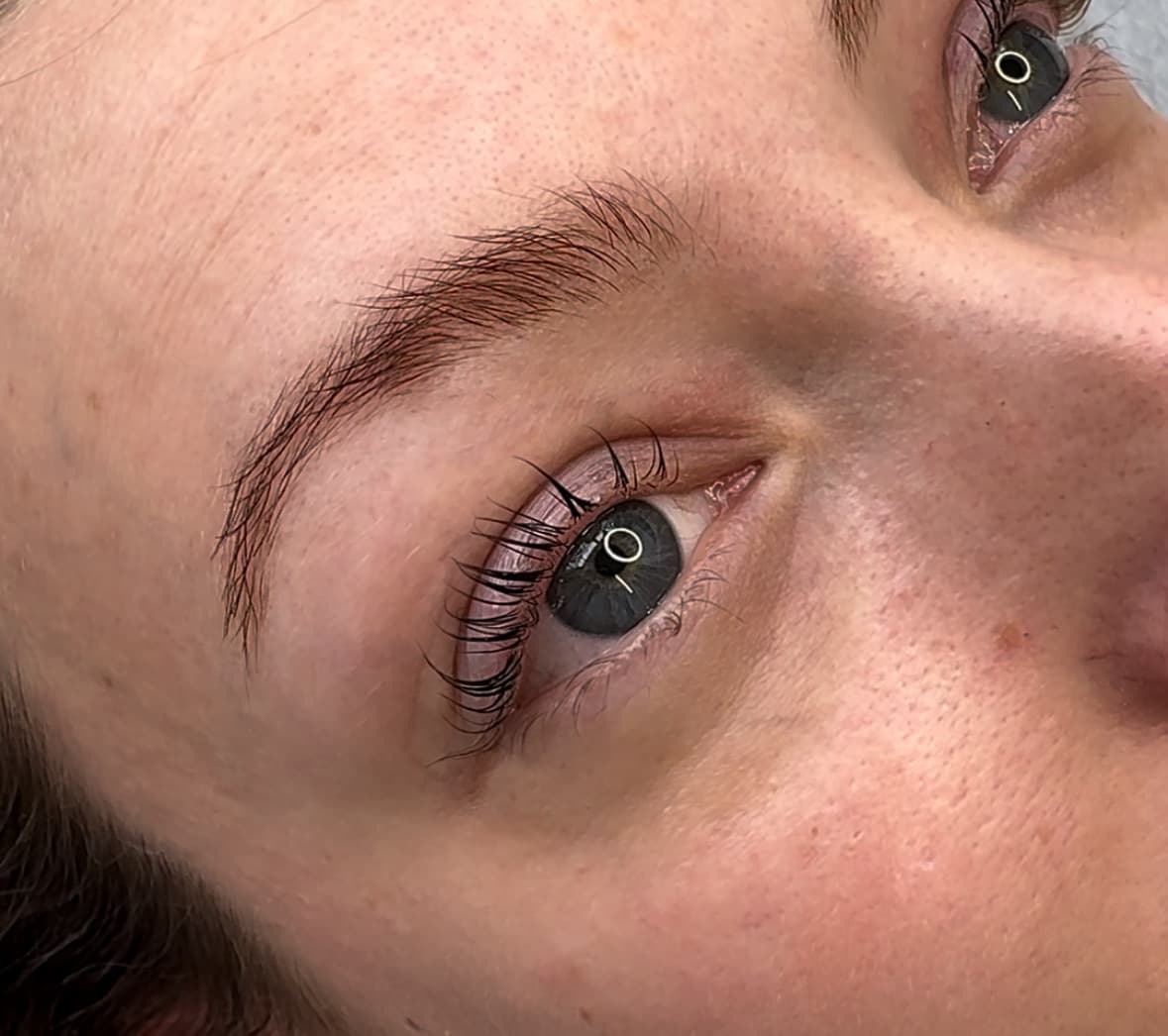 Regard ouvert et naturel avec cils recourbés sur une femme aux yeux bleus, rehaussement de cils réalisé à Dijon.